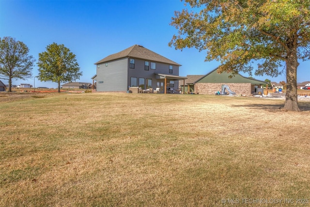 rear view of house featuring a yard