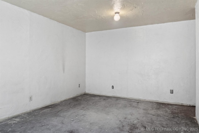 unfurnished room with concrete flooring