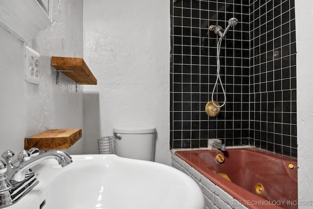 full bath with toilet, a combined bath / shower with jetted tub, a sink, and a textured wall