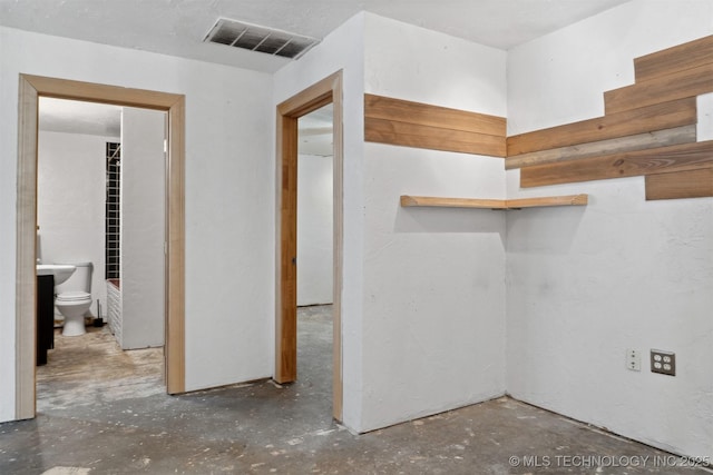 hallway featuring visible vents and unfinished concrete flooring