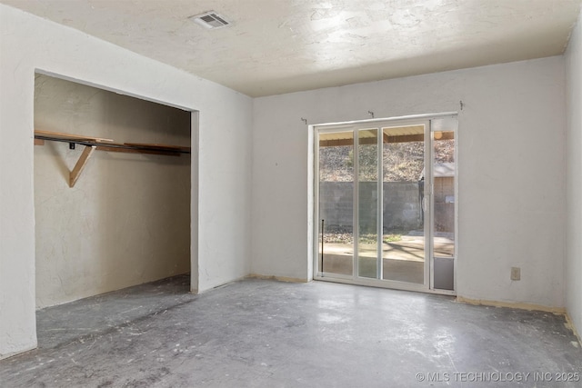 unfurnished bedroom featuring visible vents, access to exterior, unfinished concrete floors, and a closet