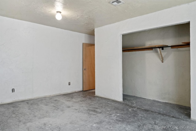 unfurnished bedroom featuring visible vents, concrete floors, and a closet