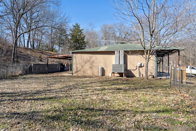 rear view of property featuring fence, an outbuilding, and an outdoor structure