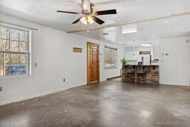 garage featuring visible vents, refrigerator with ice dispenser, and ceiling fan