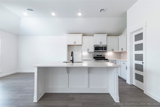 kitchen with stainless steel appliances, a kitchen island with sink, visible vents, and a sink