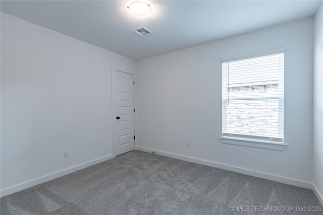 carpeted spare room featuring baseboards and visible vents