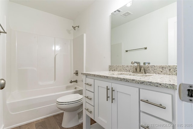 full bath with toilet, wood finished floors, visible vents, vanity, and  shower combination