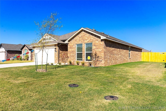 ranch-style home with an attached garage, a front lawn, concrete driveway, and brick siding