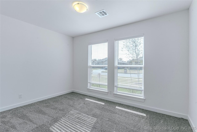 carpeted spare room featuring baseboards and visible vents