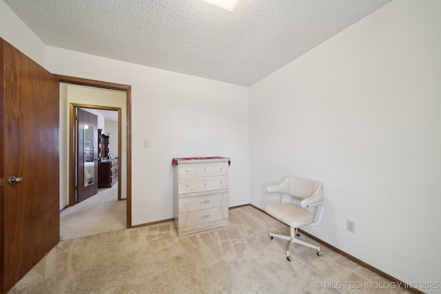 sitting room featuring a textured ceiling, carpet floors, and baseboards