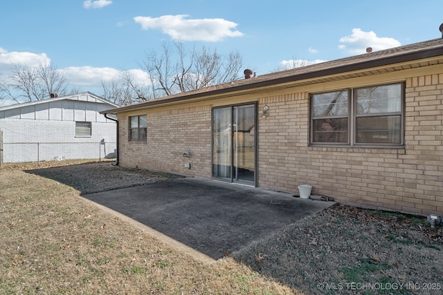 back of property with brick siding, a patio, and fence