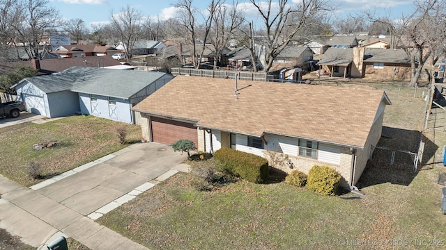 view of front of property featuring a residential view, brick siding, driveway, and an attached garage