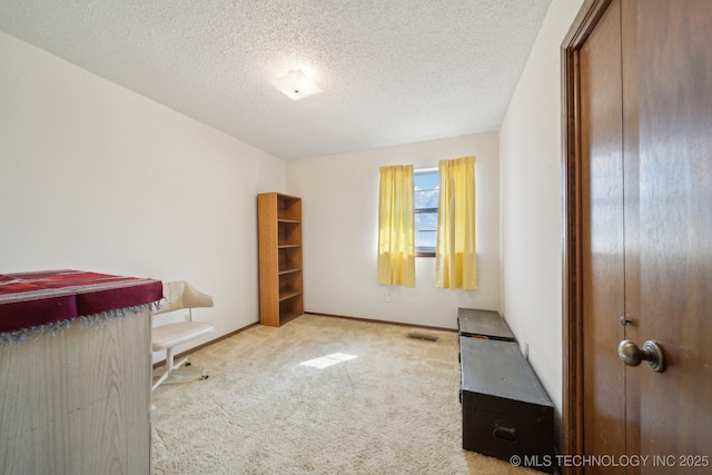 unfurnished bedroom with carpet floors, visible vents, and a textured ceiling