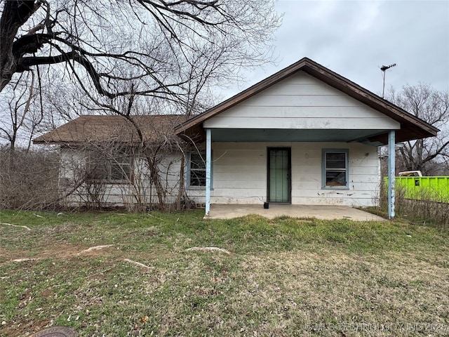 rear view of property featuring a lawn