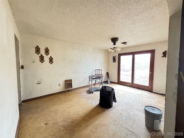 interior space with a textured ceiling and baseboards