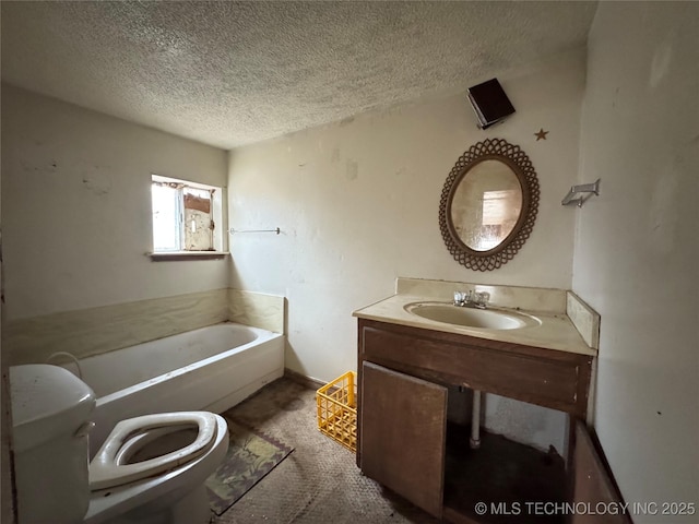 full bath with a textured ceiling, a tub to relax in, toilet, vanity, and baseboards