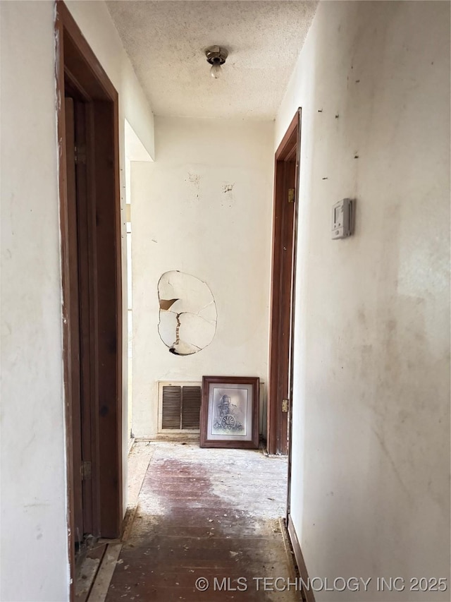 corridor featuring visible vents and a textured ceiling