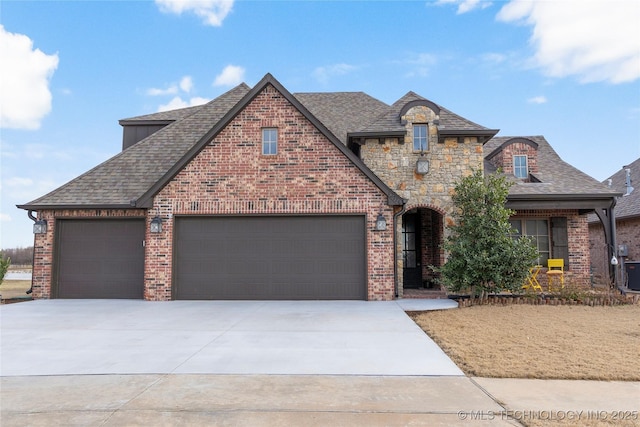 french country style house featuring stone siding, concrete driveway, and brick siding