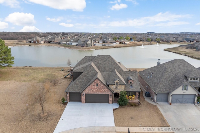 drone / aerial view featuring a residential view and a water view