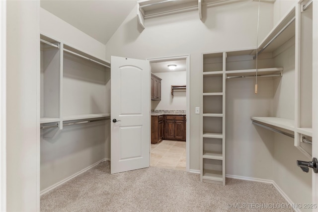 walk in closet featuring light colored carpet