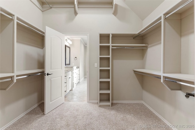 walk in closet featuring light colored carpet and light tile patterned floors