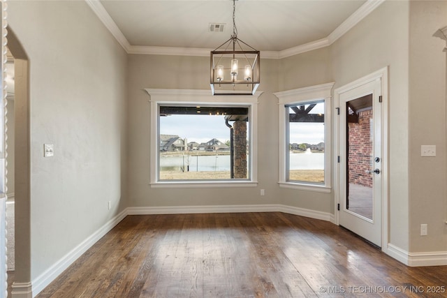 unfurnished dining area with wood-type flooring, visible vents, baseboards, and ornamental molding