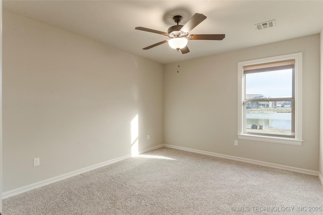 empty room with ceiling fan, carpet flooring, visible vents, and baseboards