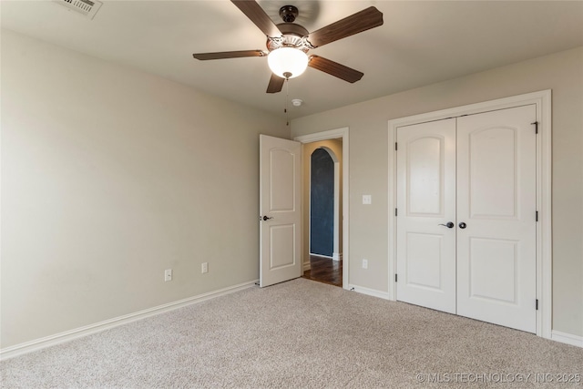 unfurnished bedroom with visible vents, baseboards, ceiling fan, carpet, and a closet