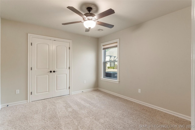 unfurnished bedroom with baseboards, visible vents, ceiling fan, carpet floors, and a closet