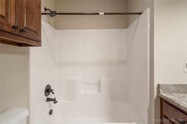 bathroom featuring bathtub / shower combination, vanity, and toilet