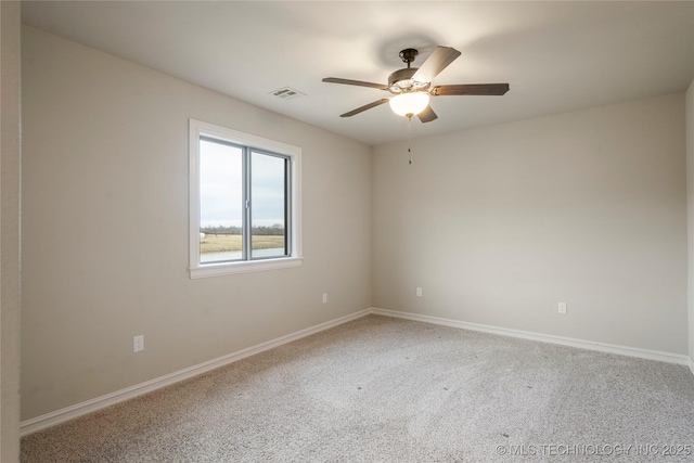 empty room featuring carpet floors, visible vents, ceiling fan, and baseboards