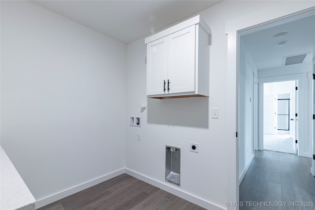 clothes washing area featuring dark wood finished floors, hookup for a washing machine, visible vents, cabinet space, and baseboards