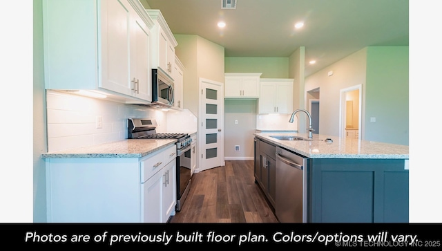 kitchen featuring white cabinets, a center island with sink, stainless steel appliances, and a sink