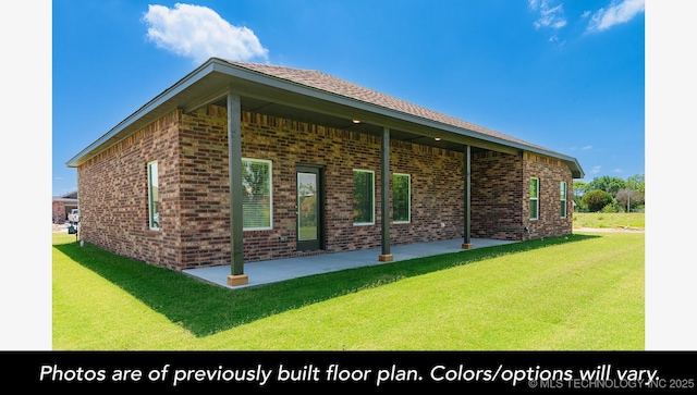 view of side of property with brick siding, a lawn, and a patio