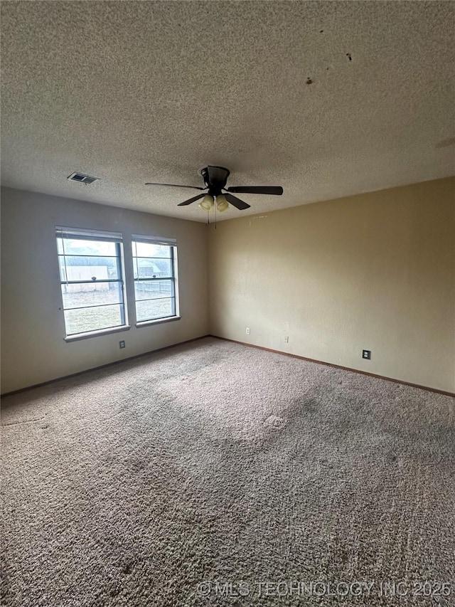 spare room with visible vents, baseboards, ceiling fan, carpet, and a textured ceiling