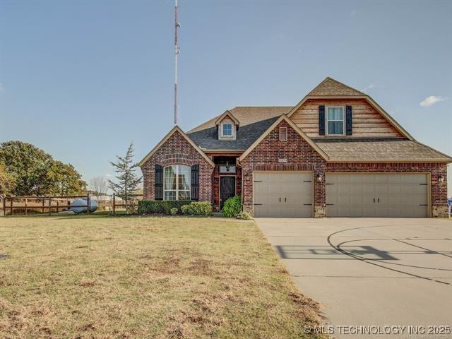 view of front facade with brick siding, driveway, and a front lawn