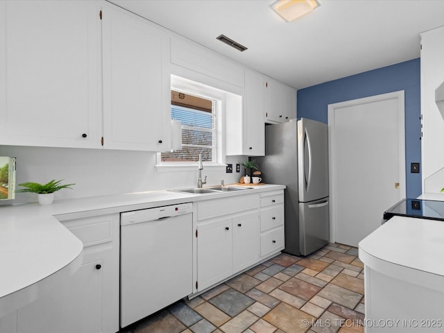 kitchen with visible vents, a sink, light countertops, white cabinets, and dishwasher