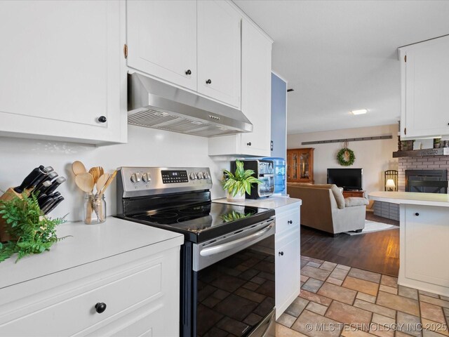 kitchen featuring under cabinet range hood, electric range, and light countertops