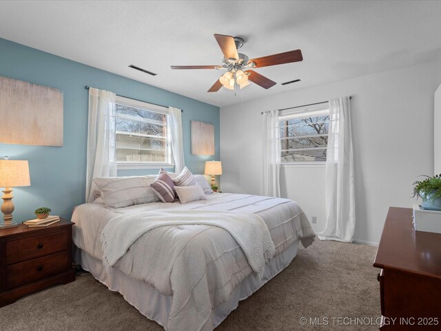 carpeted bedroom with visible vents and ceiling fan