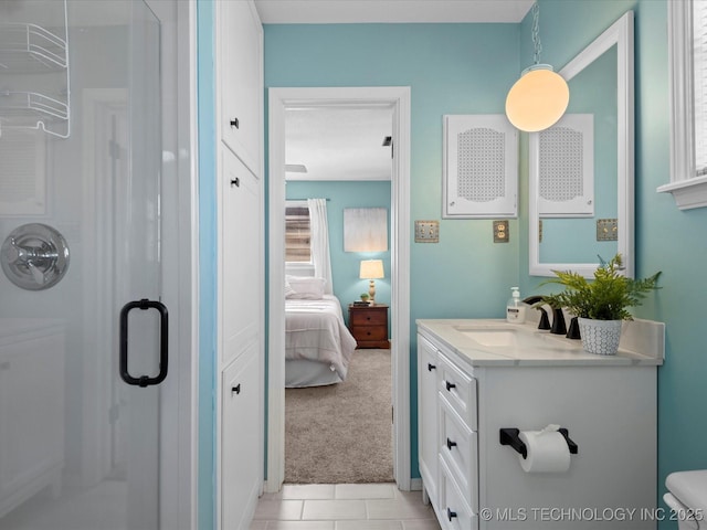 bathroom with toilet, a stall shower, ensuite bathroom, tile patterned flooring, and vanity