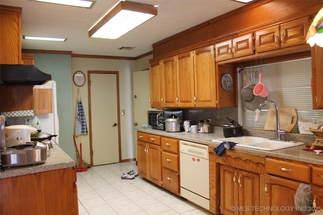 kitchen with brown cabinetry, ornamental molding, white dishwasher, a sink, and under cabinet range hood