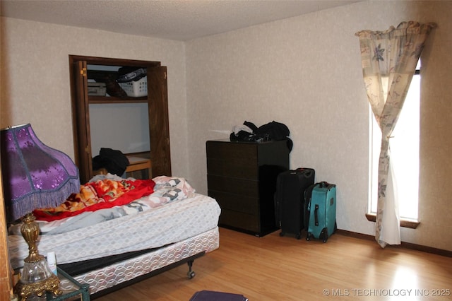 bedroom featuring wood finished floors and baseboards