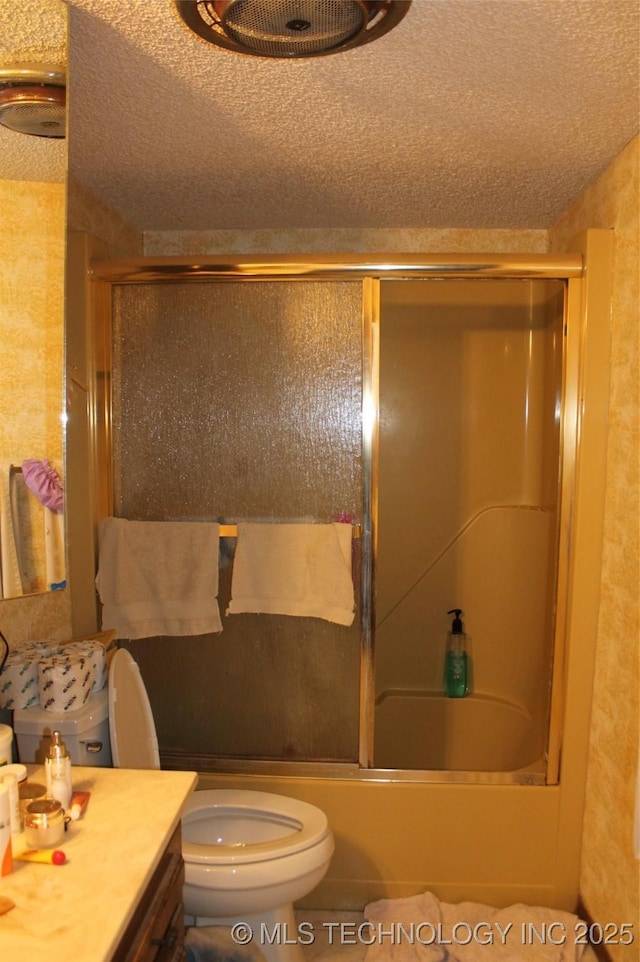 full bath with combined bath / shower with glass door, a textured ceiling, toilet, and vanity