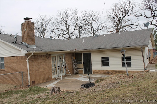 rear view of house featuring a patio, brick siding, crawl space, and a shingled roof