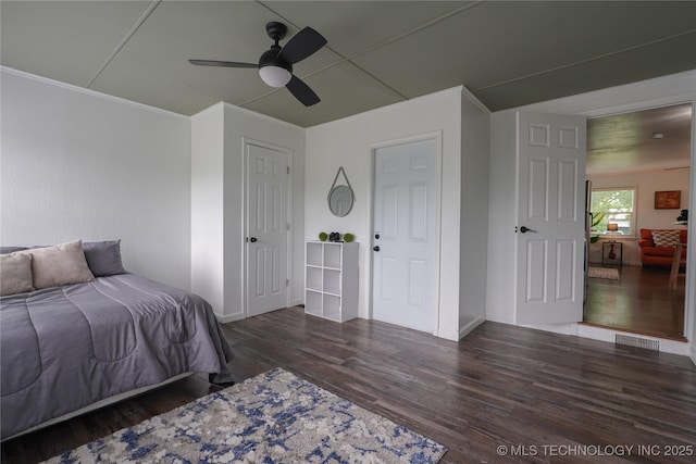 bedroom with visible vents, crown molding, a ceiling fan, and wood finished floors