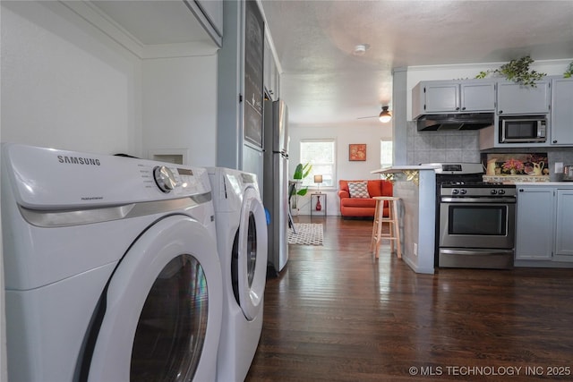 laundry room featuring washing machine and dryer, a ceiling fan, dark wood-style flooring, and ornamental molding