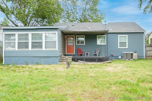 back of property featuring a yard, central AC unit, roof with shingles, and fence