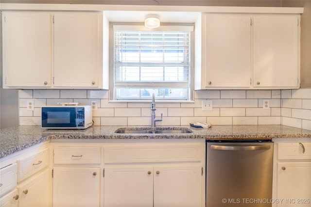 kitchen with white microwave, a sink, white cabinetry, dishwasher, and tasteful backsplash