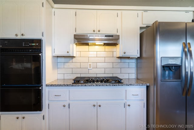 kitchen featuring backsplash, white cabinetry, dark stone countertops, under cabinet range hood, and black appliances