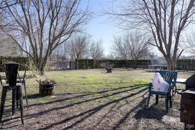 view of yard featuring a fenced backyard and a trampoline